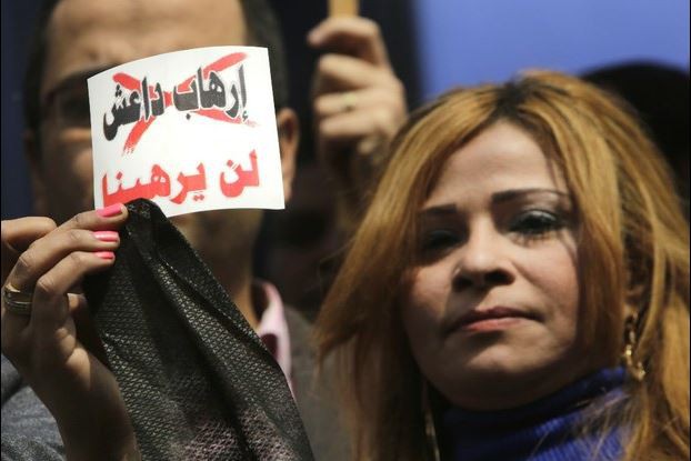 Una periodista egipcia en una protesta contra el Estado Islámico en El Cairo. El cartel en árabe dice: 
