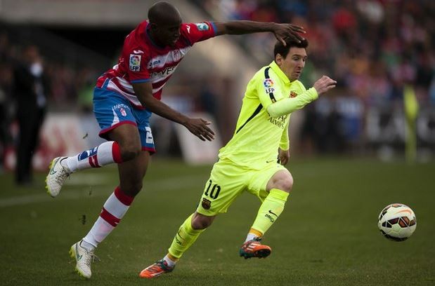 Lionel Messi, del Barcelona, disputa el control del balón ante Allan Nyom, del Granada, durante el partido correspondiente a la jornada 25 del campeonato español. Foto Ap