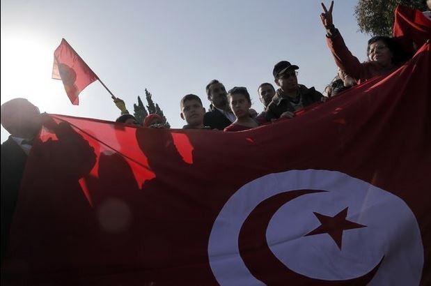 Manifestantes sostienen una bandera tunecina frente al Museo Nacional, un día después del ataque mortal contra el recinto. Foto Ap