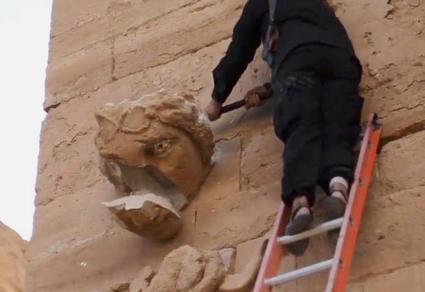 Extremista del EI destruye con un mazo la parte trasera de uno de los rostros grabados. Foto Ap