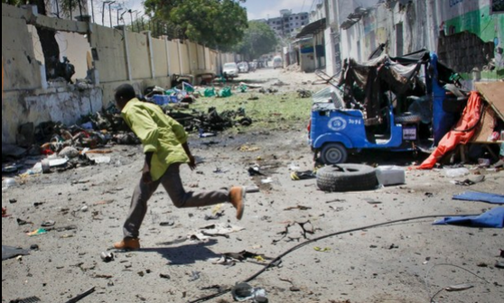 Un hombre huye del ataque que siguió a la explosión de un coche bomba en el complejo donde se encontraba el Ministerio de Educación Superior en Mogadiscio. Foto Ap