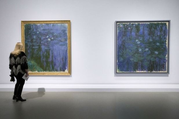 Un visitante mira 'Lirios acuáticos azules' y 'Lirios acuáticos' de Monet, en una exhibición de la Fundación Louis Vuitton en París. Foto Ap