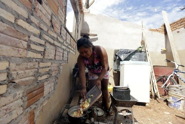 Latinoamérica enfrenta profundas brechas sociales, consideró AI. En la imagen, una mujer cocina en un vecindario pobre de Paraguay, en imagen de archivo. Foto Reuters