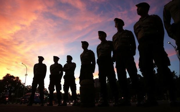 Policías indonesios montan guardia frente a una manifestación que exige detener las ejecuciones de nueve extranjeros por cargos de tráfico de drogas. Foto Ap