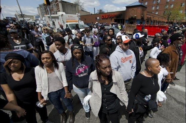 Personas cantan himnos en las calles de Baltimore, tras los enfrentamientos de ayer. Foto Ap