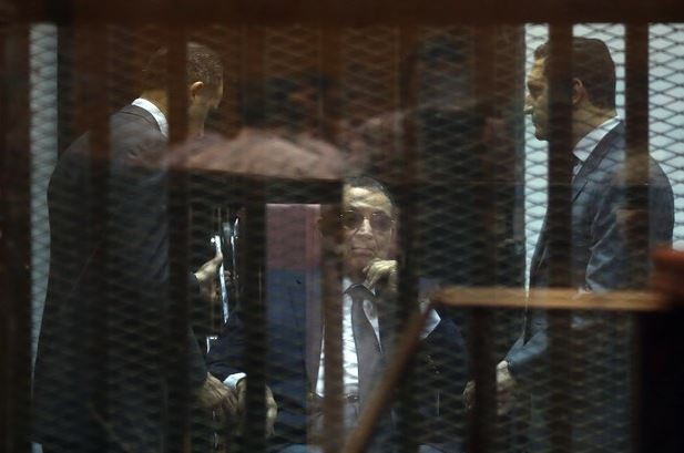 El ex presidente de Egipto Hosni Mubarak y sus hijos Gamal y Alaa, tras la rejilla en un tribunal en El Cairo. Foto Xinhua