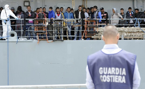 Inmigrantes que fueron 'rescatados' en el mar Mediterráneo esperan para desembarcar en el puerto de Sicilia, Italia. Foto Reuters