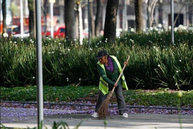 Una trabajadora de limpia barre en la Alameda Central. Foto Cuartoscuro