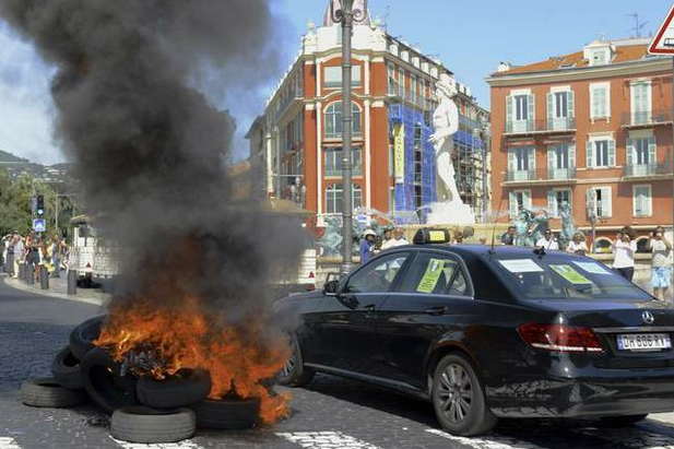 Taxistas quemaron y poncharon llantas de automóviles de choferes de la aplicación UberPop. Además, voltearon algunos de sus vehículos. Foto Reuters
