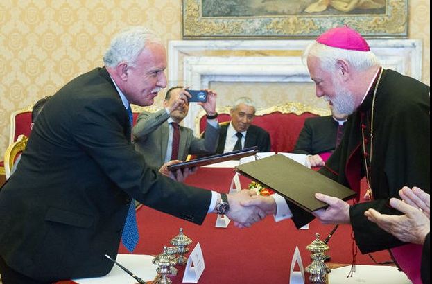 El canciller vaticano, Paul Gallagher (derecha), y su contraparte palestina, Riad Maliki, se dan un apretón de manos tras la firma del tratado. Foto Ap