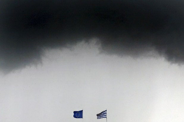 Las banderas de Grecia y de la Unión Europea ondean bajo un nuboso cielo en Atenas. Foto Reuters