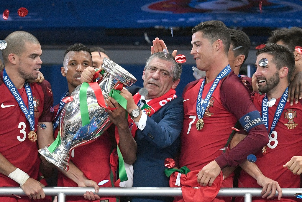 El director técnico de Portugal, Fernando Santos, sostiene el trofeo tras ganar la Eurocopa 2016, rodeado de sus jugadores. Foto Ap