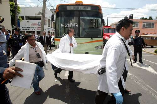 Peritos retiran el cuerpo de un hombre que fue asesinado durante un asalto a un camión de transporte público, en imagen de archivo. Foto Alfredo Domínguez