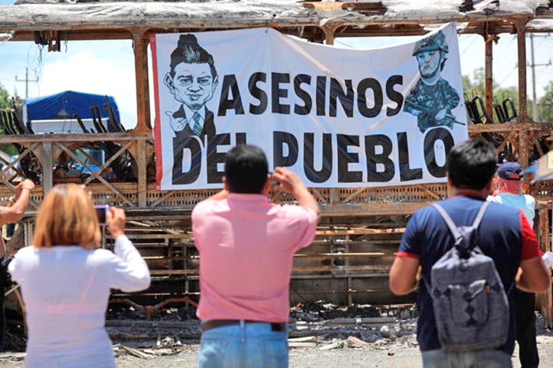 Una manta contra Peña y Nuño colocada en uno de los camiones incendiados en Nochixtlán ■ foto: proceso