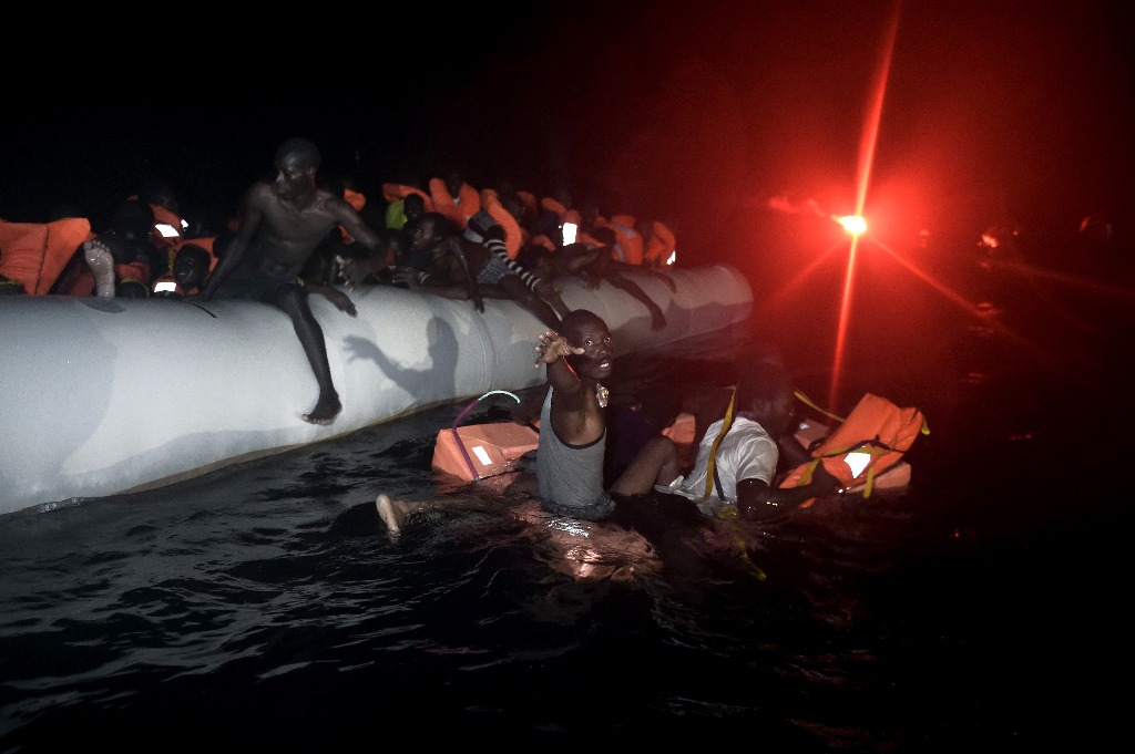 Decenas de migrantes a bordo de una bote inflable esperan ser rescatados, en la costa de Libia. Foto Afp