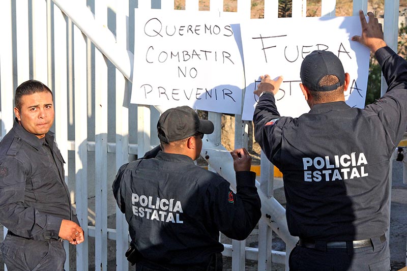 Los agentes inconformes colocaron cartulinas con mensajes ■ FOTO: RAFAEL DE SANTIAGO