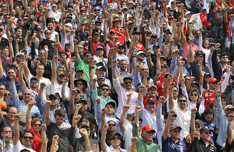 CIUDAD DE MÉXICO. En la vuelta 19 del Gran Premio de México, el público se puso de pie y levantó el puño en señal de homenaje a las víctimas del sismo del pasado 19 de septiembre, así como a los brigadistas que trabajaron en el rescate. Unos 155 mil asistentes a la prueba de automovilismo colmaron el autódromo Hermanos Rodríguez este domingo. Antes de la competencia también se guardó un minuto de silencio y una banda de guerra hizo el toque de silencio n FOTO: la jornada