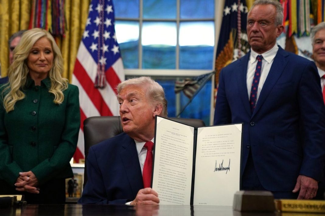 El presidente Donald Trump sostiene una orden ejecutiva firmada sobre la recuperación de las adicciones en la Oficina Oval de la Casa Blanca, el jueves 29 de enero de 2026, en Washington, mientras Kathryn Burgum y el secretario de Salud y Servicios Humanos, Robert F. Kennedy Jr., observan. Foto: La Jornada.