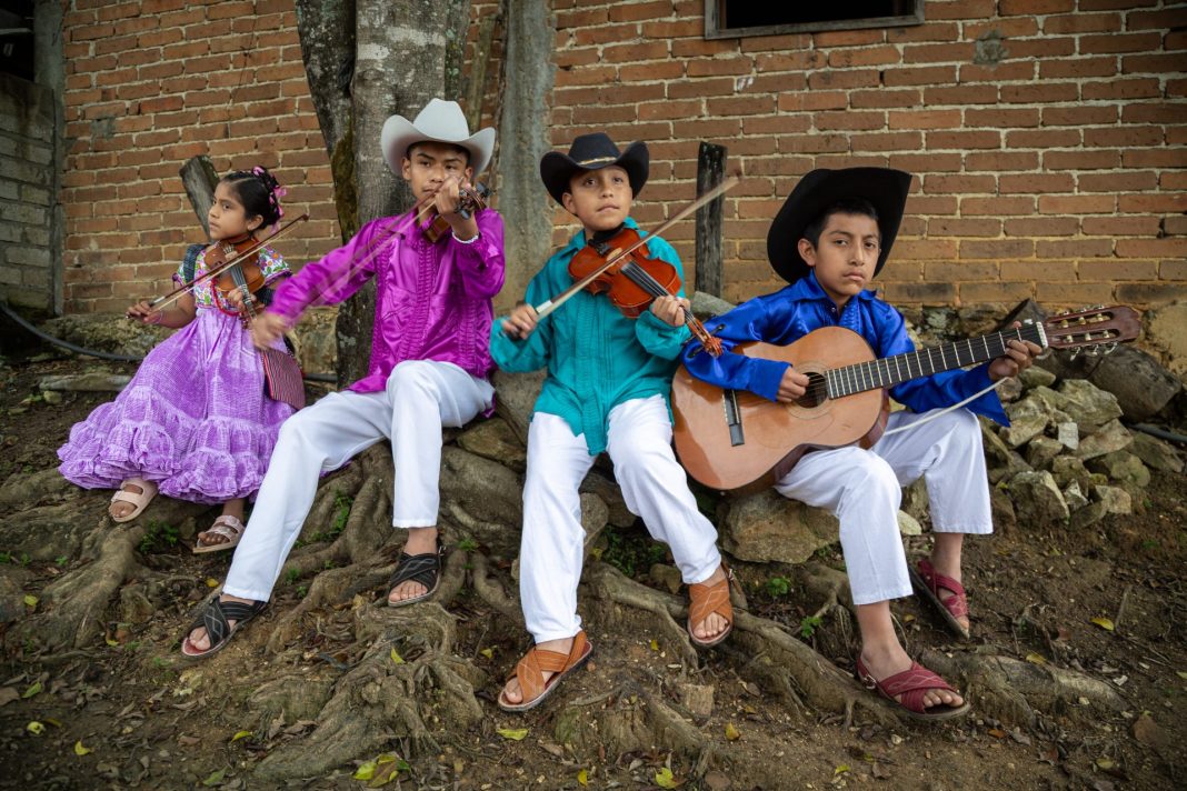 Integrantes del grupo local Notas Chatinas se preparan para presentarse en una escena de la película La Raya.
